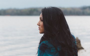 Angst- und Panikstörungen - Frau mit schwarzen Haaren, die aufs Wasser guckt