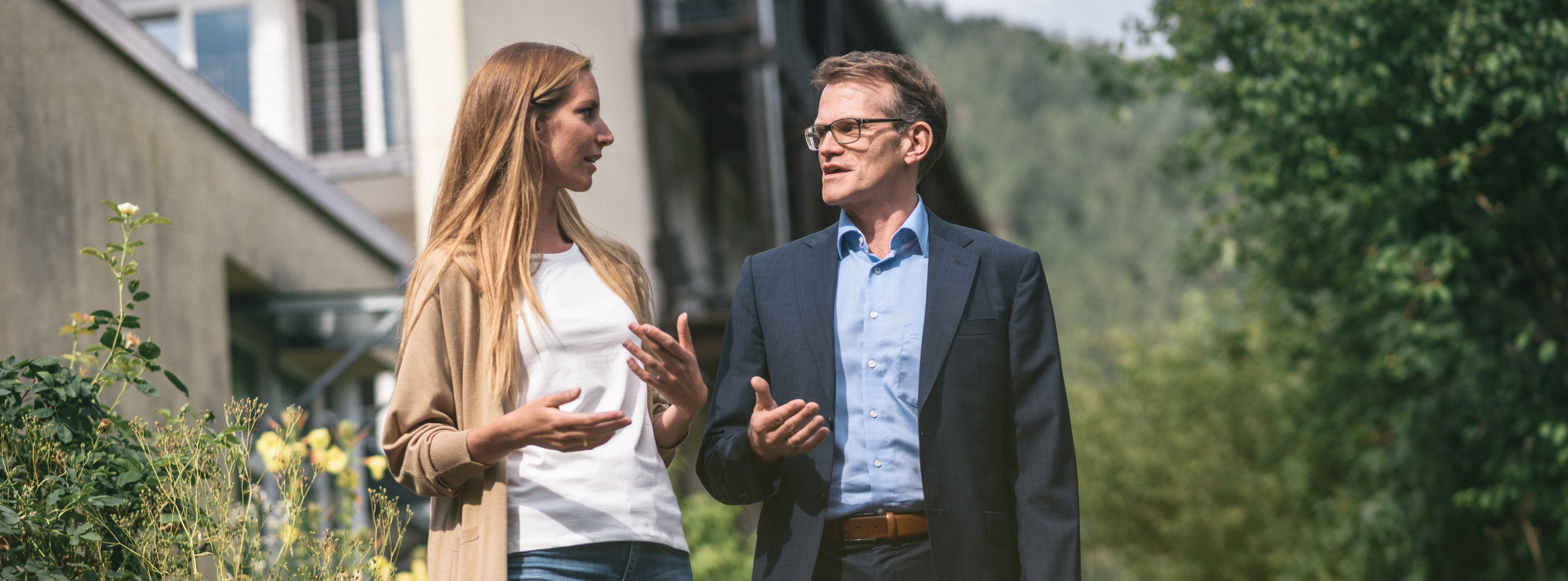 Arzt im Gespräch mit Patientin während eines Spaziergangs im Freien