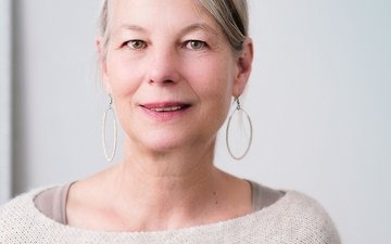 Wie gehe ich mit Midlife-Crisis um? Frau blickt zuversichtlich
