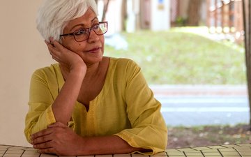 Psychische Belastung bei Flüchtlingshelfern Artikel Flüchtlingshelfer: Alte Frau an einem Tisch