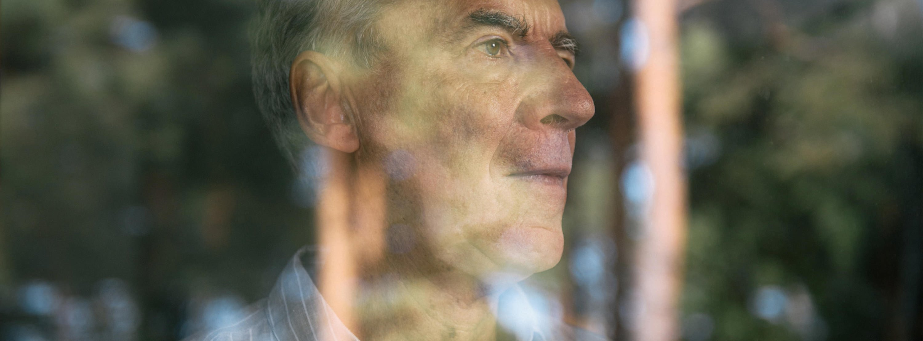 ADHS behandeln Mann hinter spiegelnder Fensterscheibe in Behandlungsraum