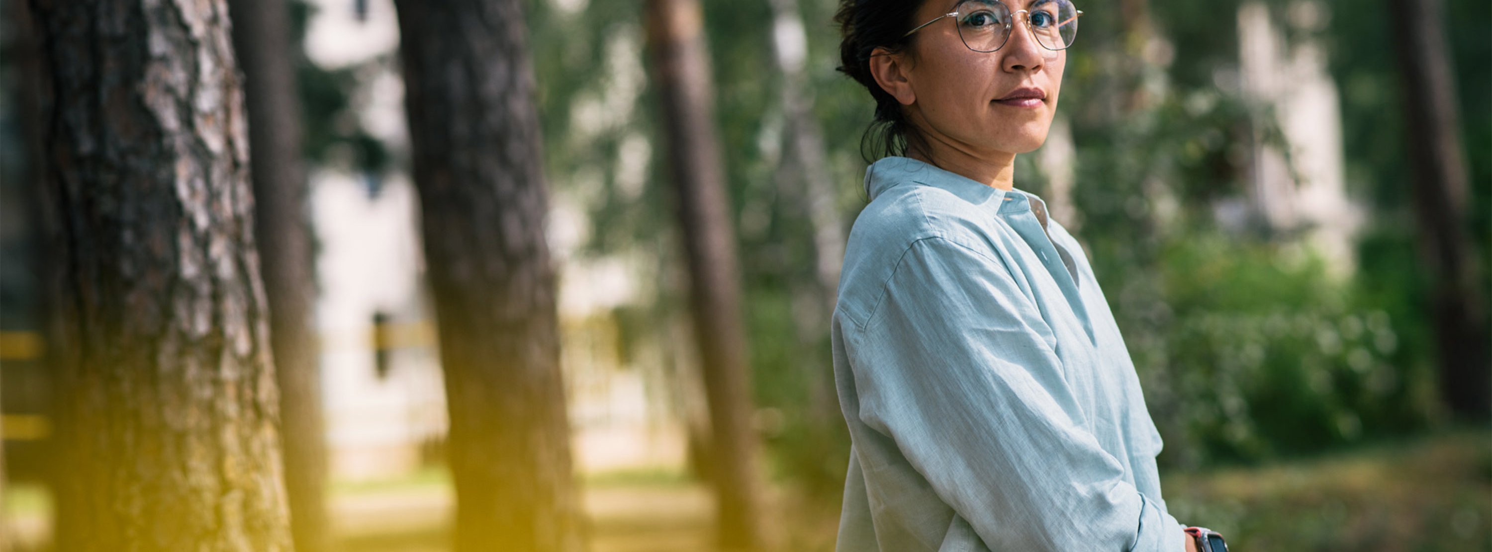 Angststörung erfolgreich therapieren Eine Frau im Profil, im Hintergrund Bäume: Therapie der Angststörung in heilsamer Umgebung