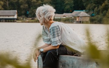 Depression: Eine Frau mit weißen Haaren sitzt am Wasser