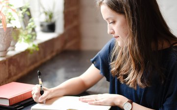 Therapietagebuch Ratgeber: Die heilsame Wirkung des Schreibens Artikel Therapietagebuch Frau mit Buch und Stift