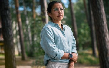 Resilienz - Frau mit blauem Oberteil und Brille im Wald