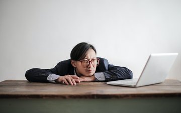 Mann langweilt sich vor Laptop