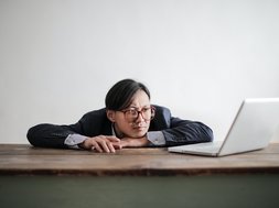 Mann langweilt sich vor Laptop