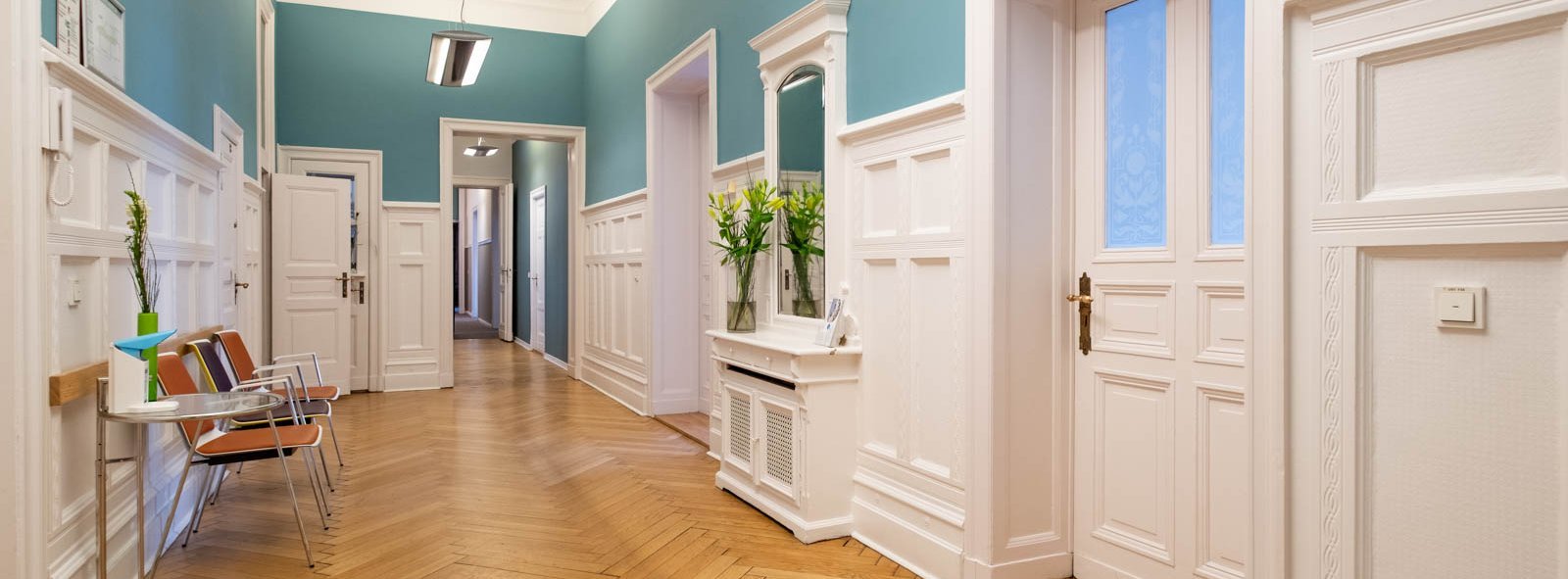 Einblick in die Tagesklinik Kurfürstendamm, heller Holzfußböden, Wände in weiß und türkis