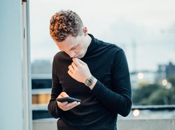 Was ist eine Zwangsstörung? Artikel Zwangsstörung Mann mit Handy in der Hand