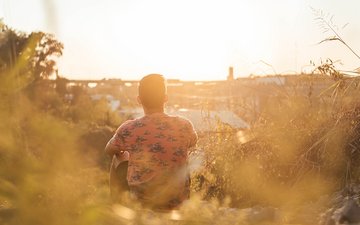 Trauma - Mann der in einem Feld sitzt