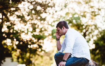 Frühjahrsmüdigkeit & Frühjahrsdepression: Symptome, Unterschiede & Auswege Artikel Frühjahrsmüdigkeit Mann mit der Hand vor dem Gesicht