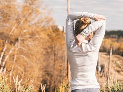 Was macht glücklich? Artikel Glücklichkeit Frau vor Bäumen