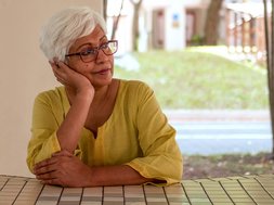 Vogelzwitschern und Sonnenstrahlen – trotzdem frühlingsmüde? Artikel Frühlingsmüdigkeit alte Frau am Tisch