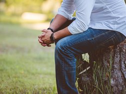 Neuer Therapiegarten der Rhein-Jura Klinik: Erschaffen, Erleben und Erfühlen mit allen Sinnen Artikel Therapiegarten Rhein-Jura: Mann sitzt auf einem Baumstamm