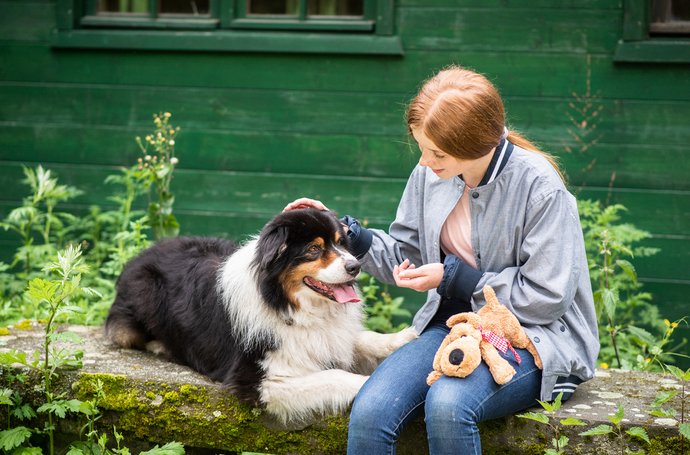 Behandlung von Persönlichkeitsstörungen Artikel Persönlichkeitsstörungen: Frau mit Hund vor grünem Haus
