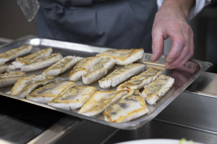 Fischfilet wird auf einem Backblech vorbereitet