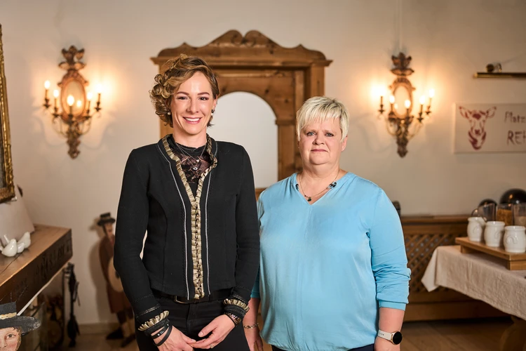 Zwei Frauen stehen in einem historischen Innenraum