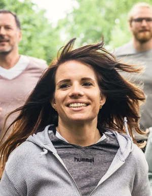 mehrere Personen joggen durchs Gr&uuml;ne