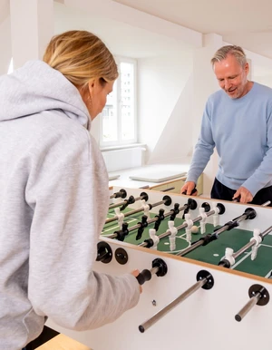 Zwei Personen spielen Tischkicker