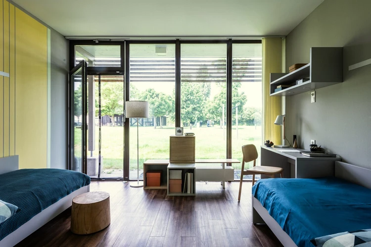 Patientenzimmer mit Bett und Blick in den Garten