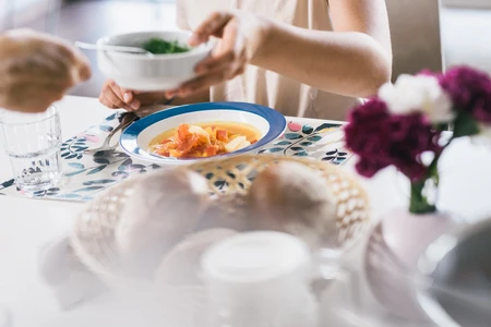 Gedeckter Tisch mit Brotkorb und Suppe