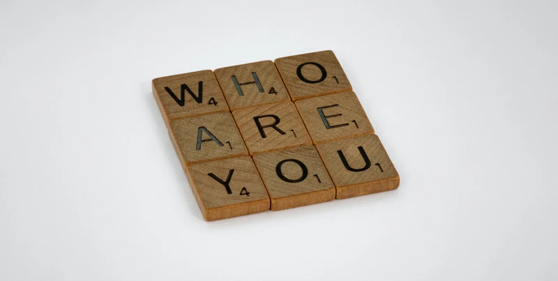 Holzbuchstaben bilden die Frage Who are you