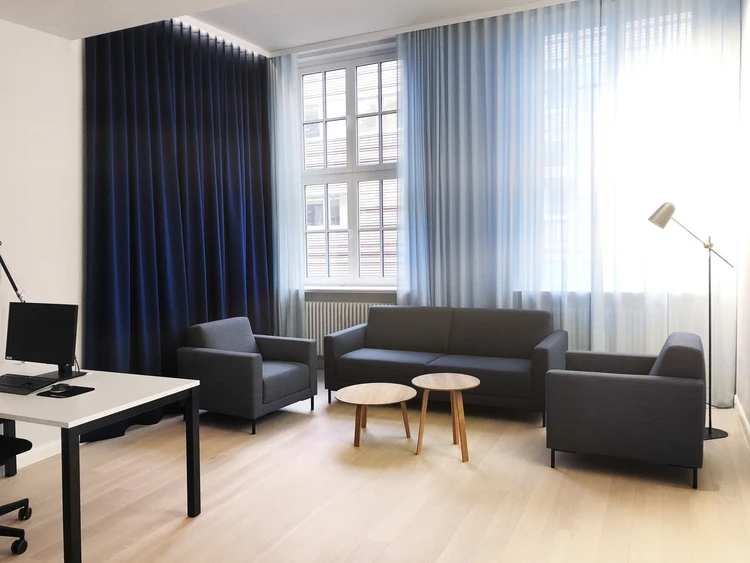 Sitzbereich mit Sofa und Sesseln in einem hellen Raum