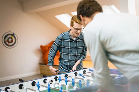 Zwei Personen spielen Tischkicker