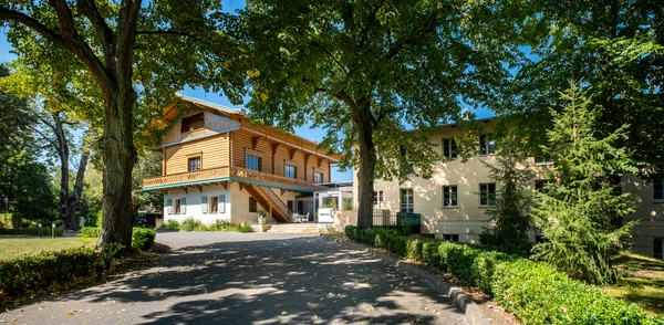 Au&szlig;enansicht der Oberberg Fachklinik Potsdam mit historischem Geb&auml;ude und B&auml;umen