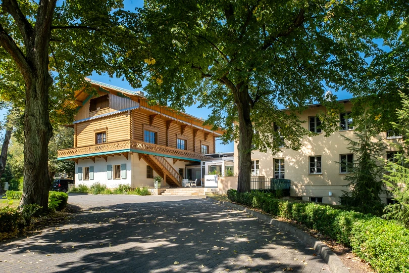 Au&szlig;enansicht der Oberberg Fachklinik Potsdam mit historischem Geb&auml;ude und B&auml;umen