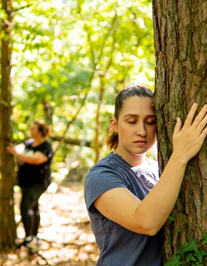 Personen bei einer Achtsamkeits&uuml;bung im Wald