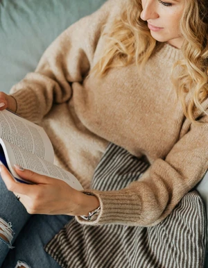 Person h&auml;lt ein Buch auf dem Scho&szlig;