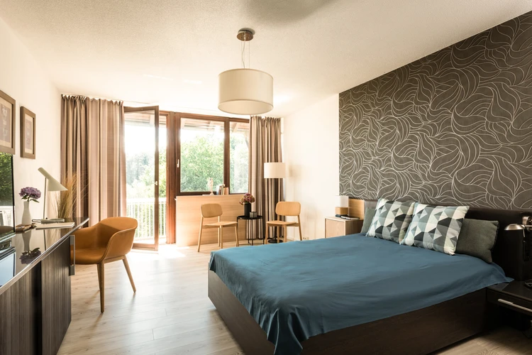 Helles Patientenzimmer mit Bett und Sitzecke
