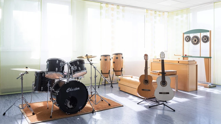 Musikraum mit Instrumenten und gro&szlig;en Fenstern