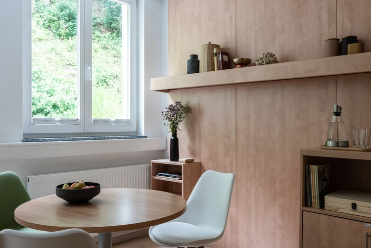 Heller Wohnbereich mit Tisch und Stuhl am Fenster
