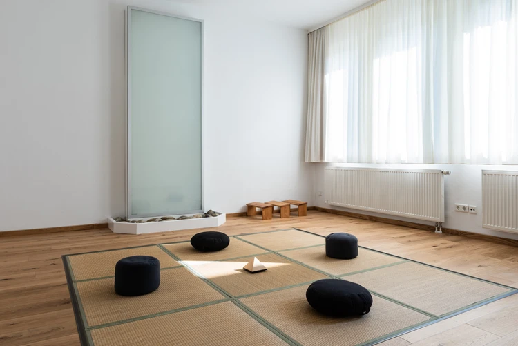 Heller Bewegungsraum mit Sitzkissen und gro&szlig;en Fenstern
