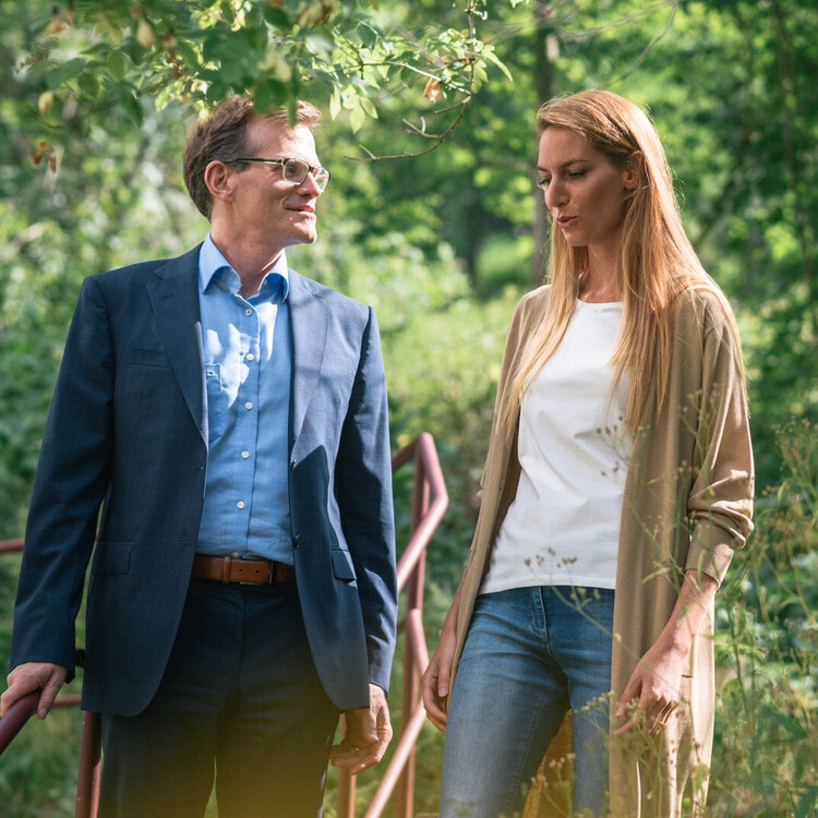 Frau und Mann gehen im Gr&uuml;nen miteinander ins Gespr&auml;ch vertieft