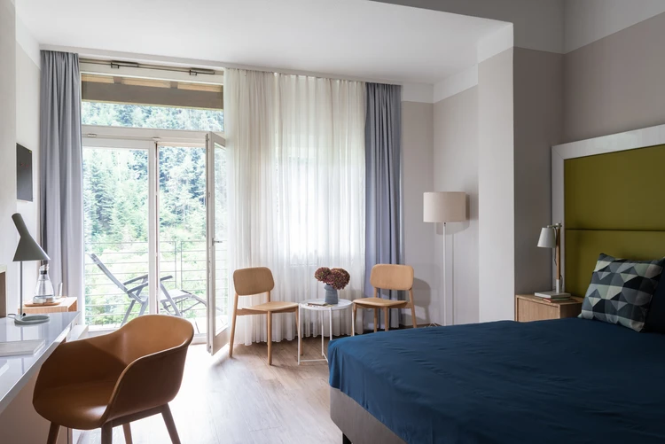 Helles Patientenzimmer mit Bett und gro&szlig;em Fenster
