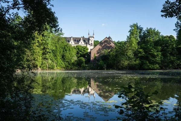 Blick &uuml;ber einen See auf das Wasserschl&ouml;sschen im Gr&uuml;nen