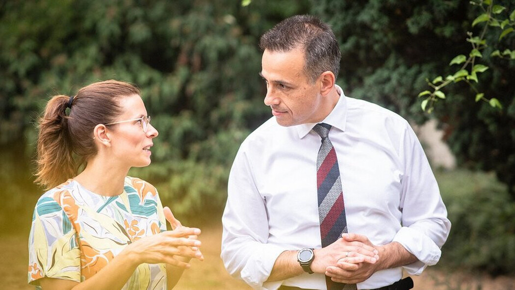 Frau und Mann gehen im Gr&uuml;nen miteinander ins Gespr&auml;ch vertieft