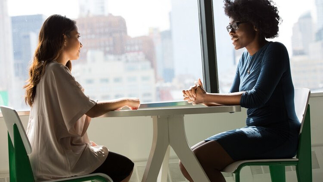 Zwei Frauen sitzen an einem Tisch im Gespr&auml;ch