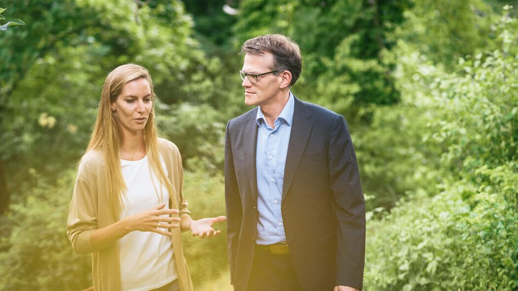 Frau und Mann gehen im Gr&uuml;nen miteinander ins Gespr&auml;ch vertieft