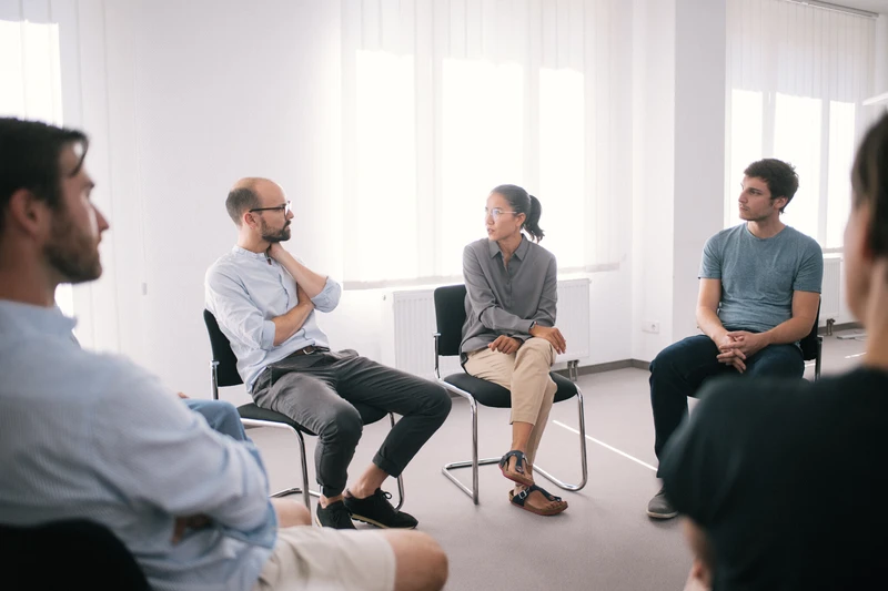 Therapie Gruppe sitzt zusammen in einem hellen wei&szlig;en raum