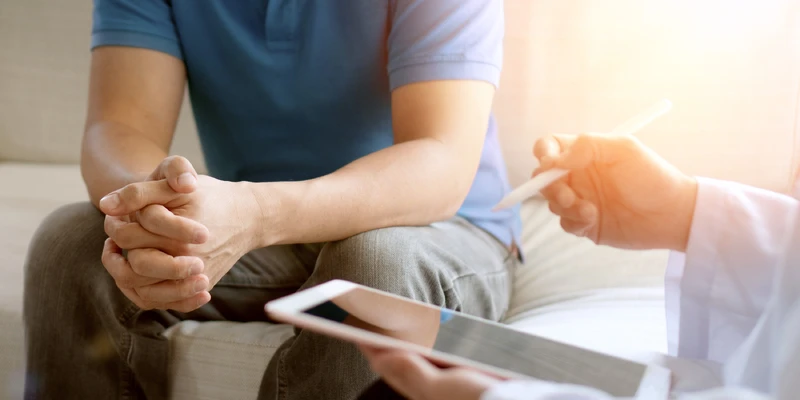 Nahaufnahme von den H&auml;nden eines Mannes der Therapie Fragen beantwortet.